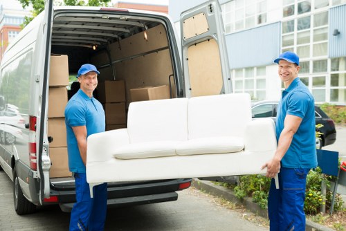 Local movers handling boxes and furniture for a Canary Wharf flat move